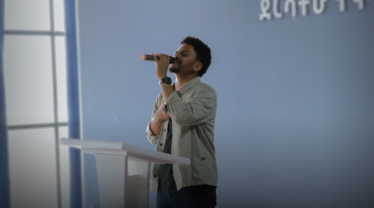 A worship leader singing at the front